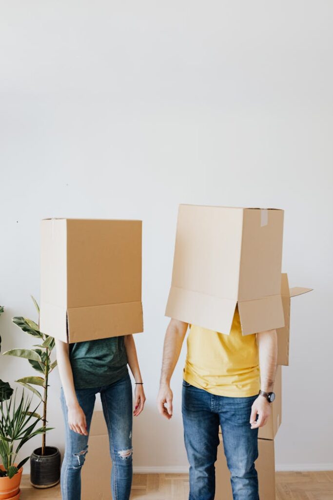 pexels-photo-4506261 Young couple having fun with boxes while moving into a new apartment.